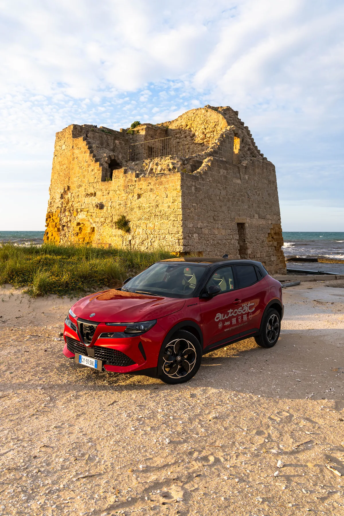 Alfa Romeo Junior sulla sabbia, accanto a una torre costiera salentina
