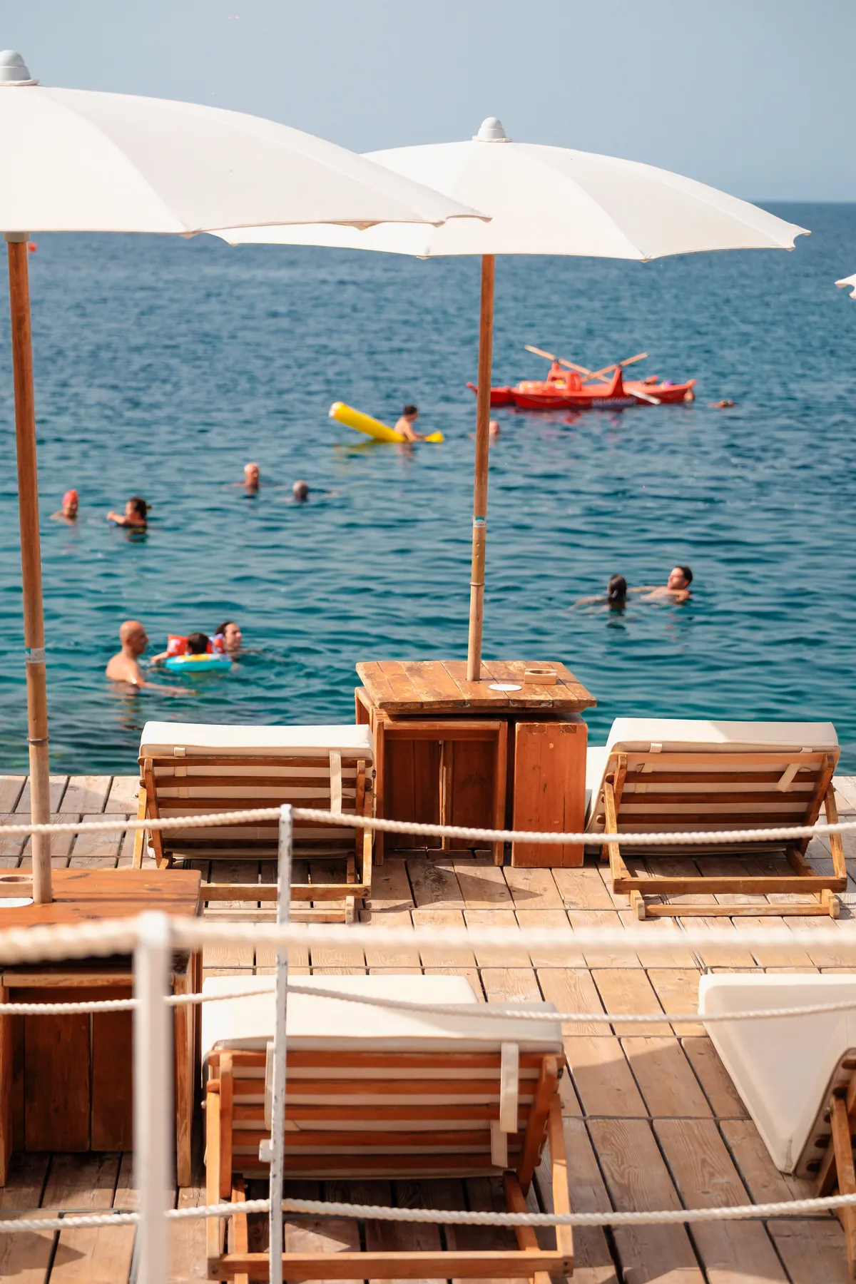 La pedana in legno con ombrelloni e lettini sul mare