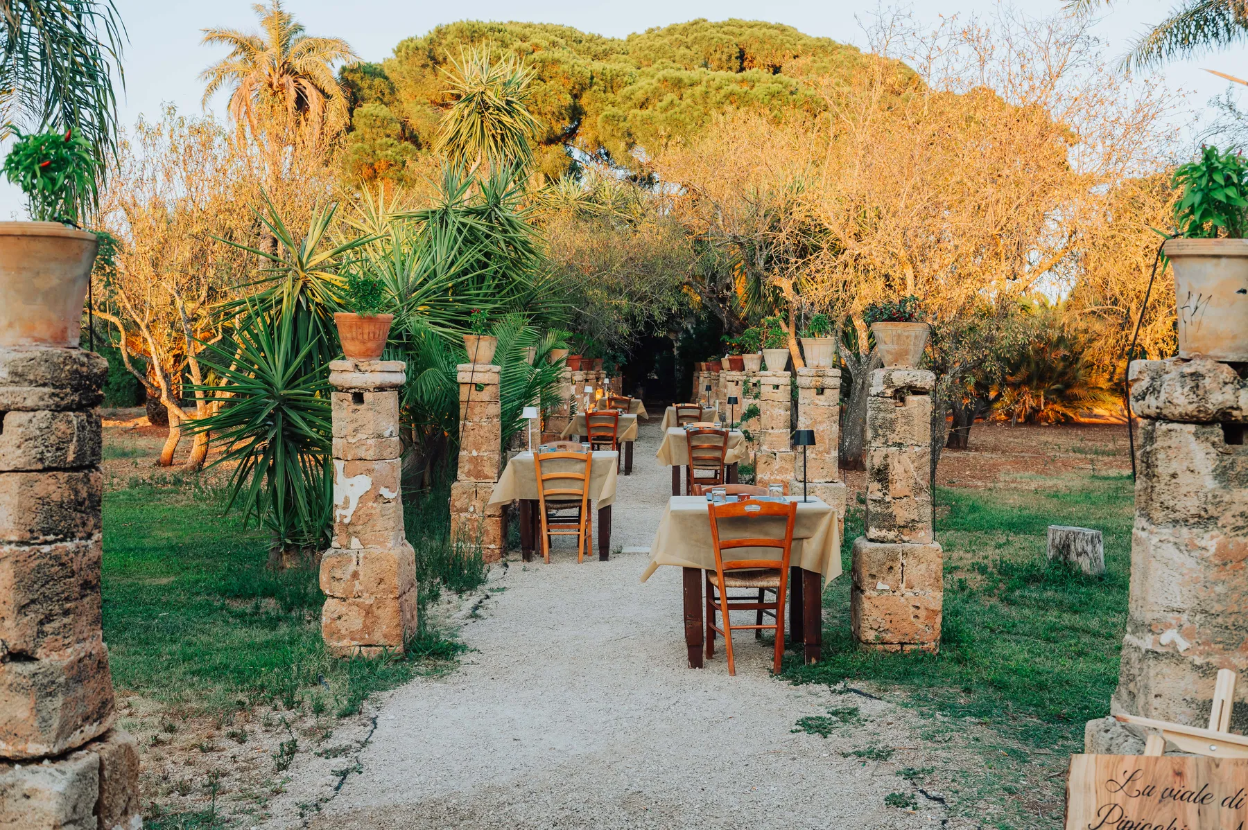 Il giardino della masseria con i tavoli tra le colonne in pietra