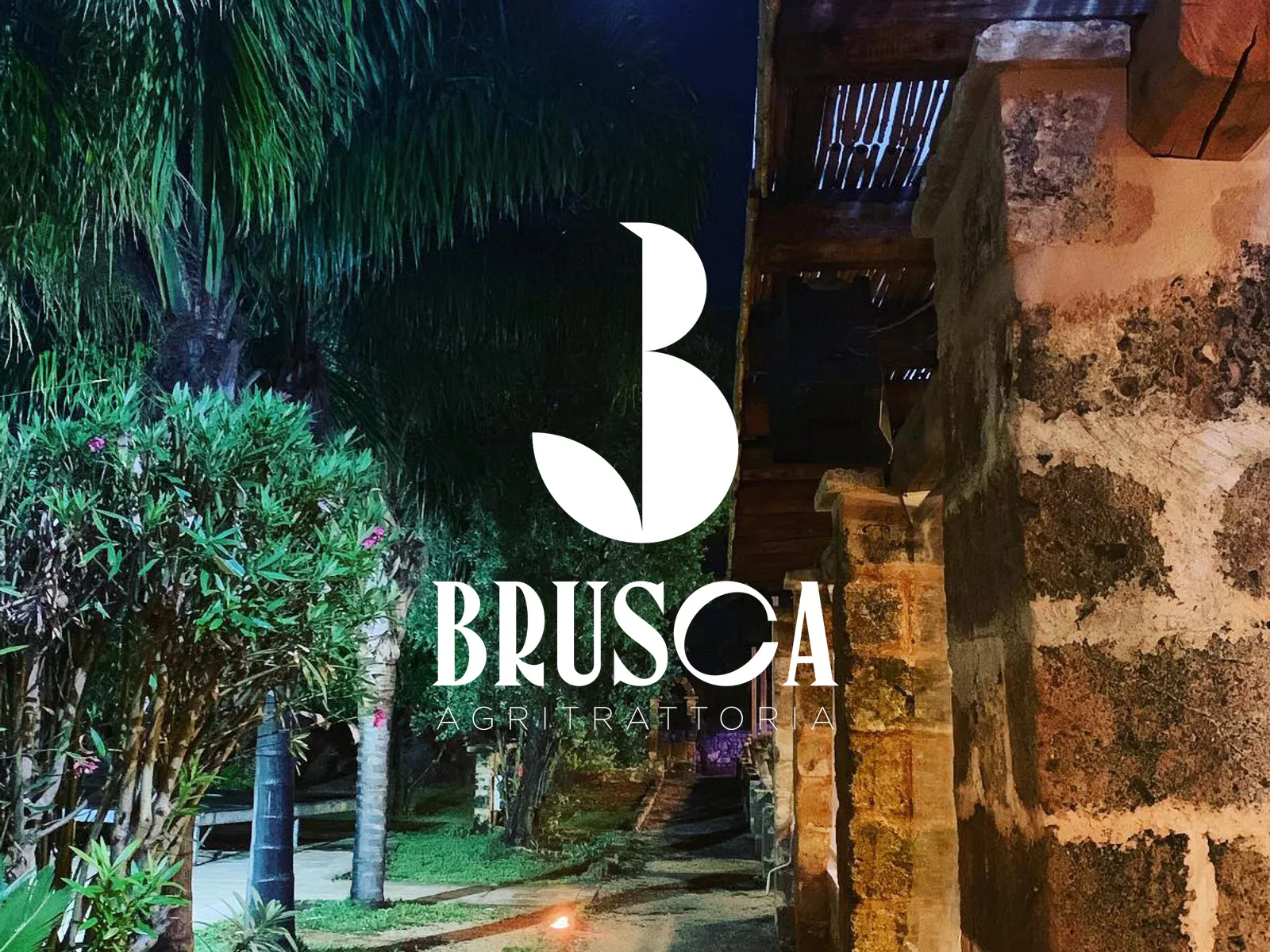 Il logo bianco sopra una foto notturna della masseria